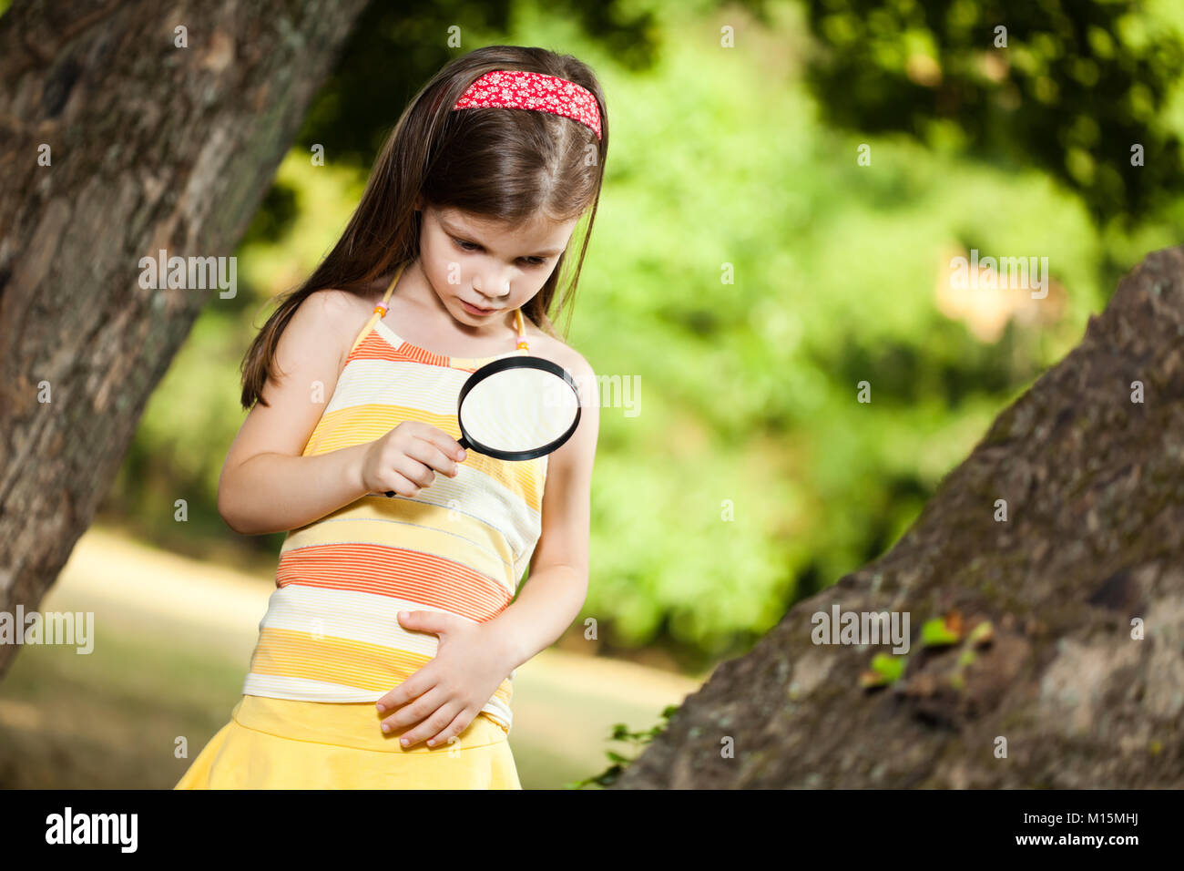 Little girl exploring nature with loupe Stock Photo - Alamy