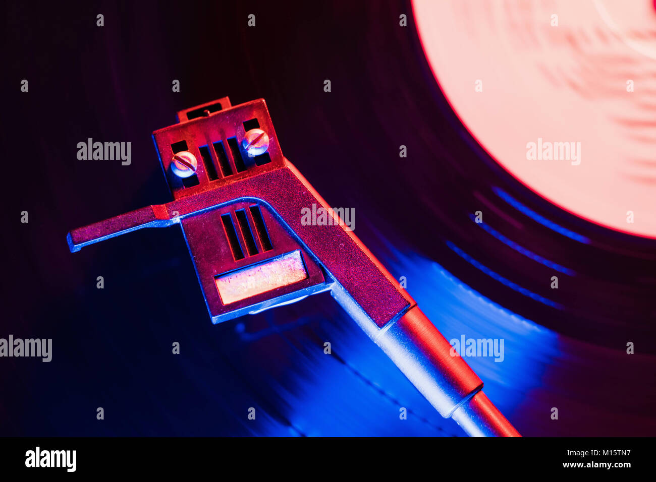 Movie of retro-styled record player spinning vinyl black record. Cinemagraph. Top view. Beautiful neon night colors. Stock Photo