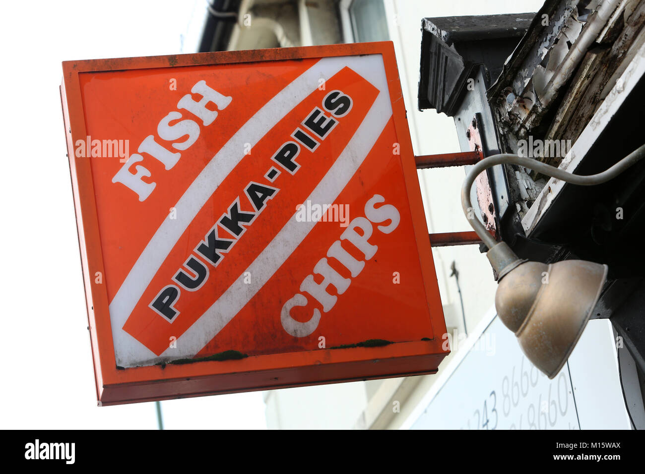 An old Fish and Chips and Pukka-Pies sign outside a chip shop in Bognor Regis, West Sussex, UK. Stock Photo
