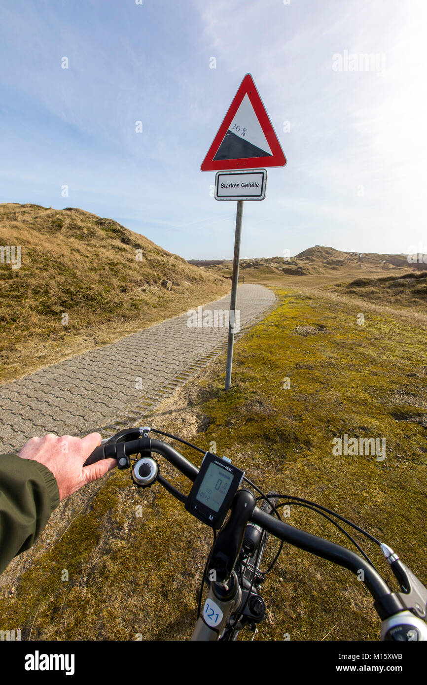 The East Frisian North Sea island of Norderney, Germany, in winter, Wadden Sea National Park, cyclist, bike tour, bike path, incline, gradient, path i Stock Photo