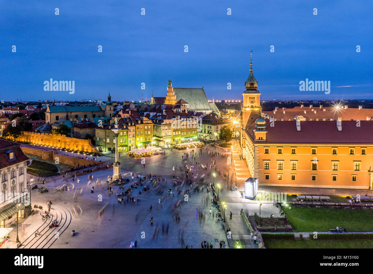 Royal Castle and Sigmund Column monument with many people passing by in the evening,Warsaw,Poland Stock Photo