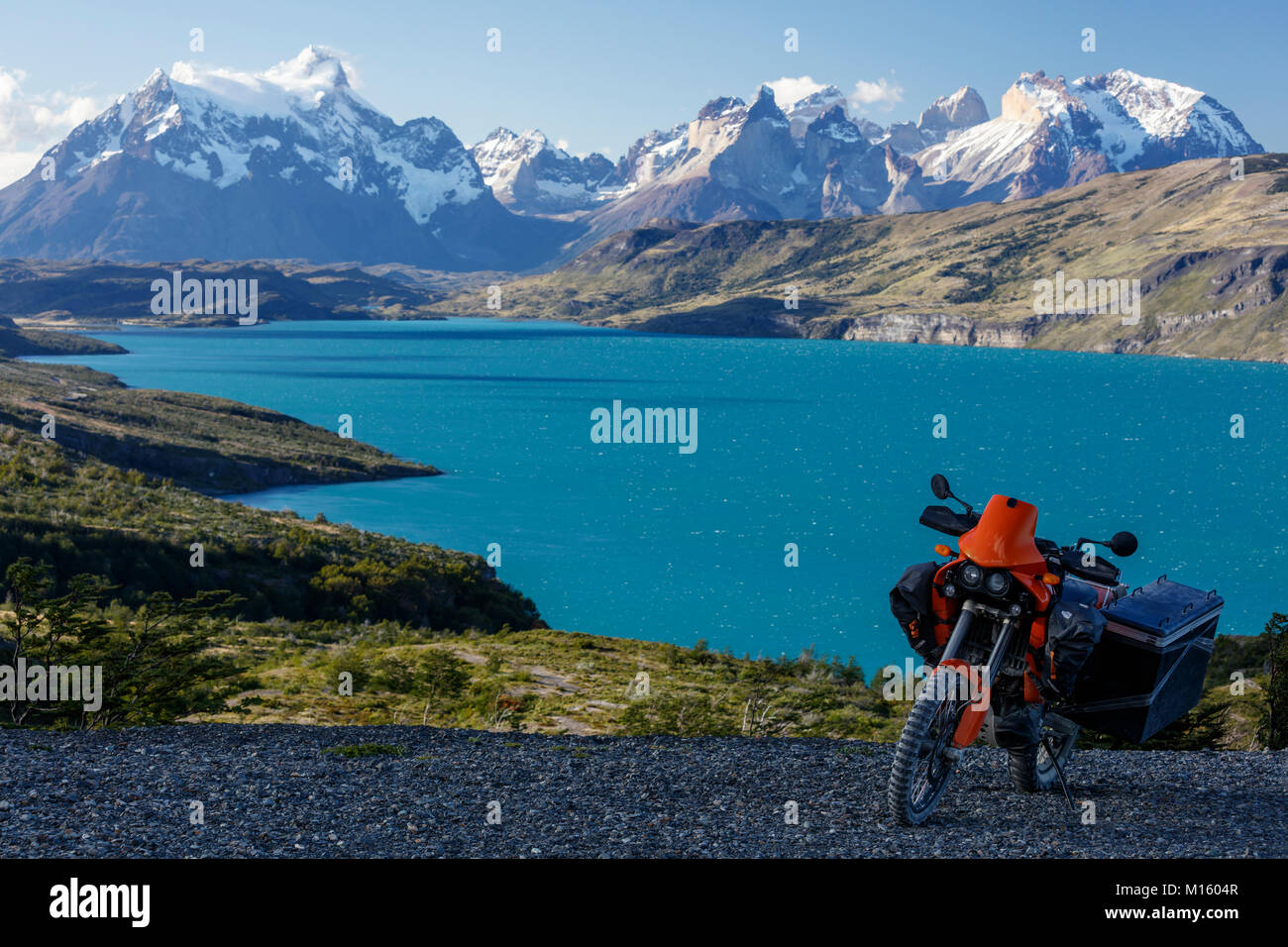 A heavily packed motorcycle on a gravel road behind the Lago del Torro and the mountain group Cordillera Paine,Torres de Paine, Stock Photo