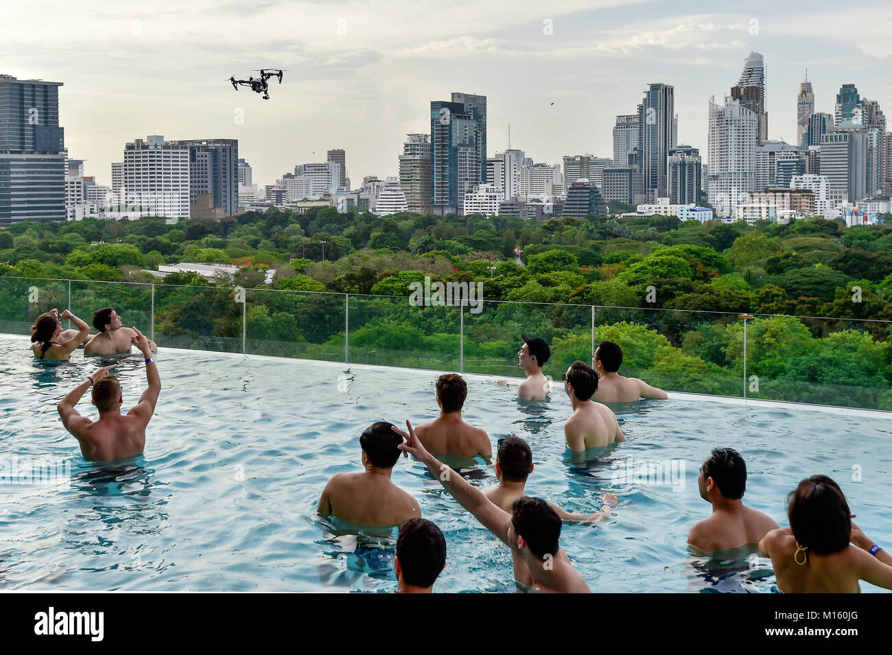 DJI Inspire 1 drone flies over Swimminpgool,in the background Skyline of Bangkok,Thailand Stock Photo