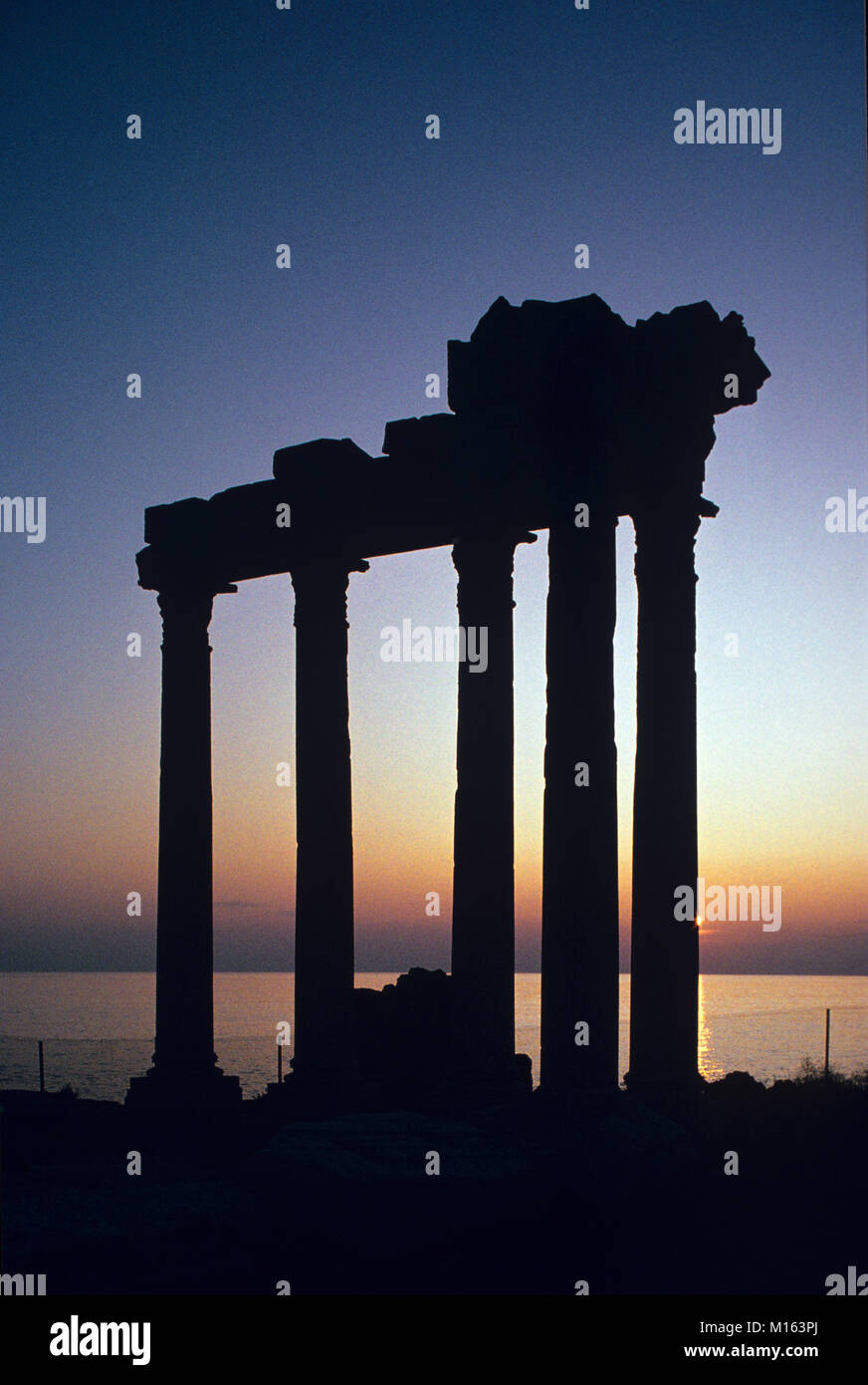 Dusk or Sunset over the Ancient Greek Temple of Apollo (c2nd) in the Remains or Ruins of the Antique Greek City of Side, on the Side Peninsula Overlooking the Mediterranean Sea, Antalya, Turkey Stock Photo