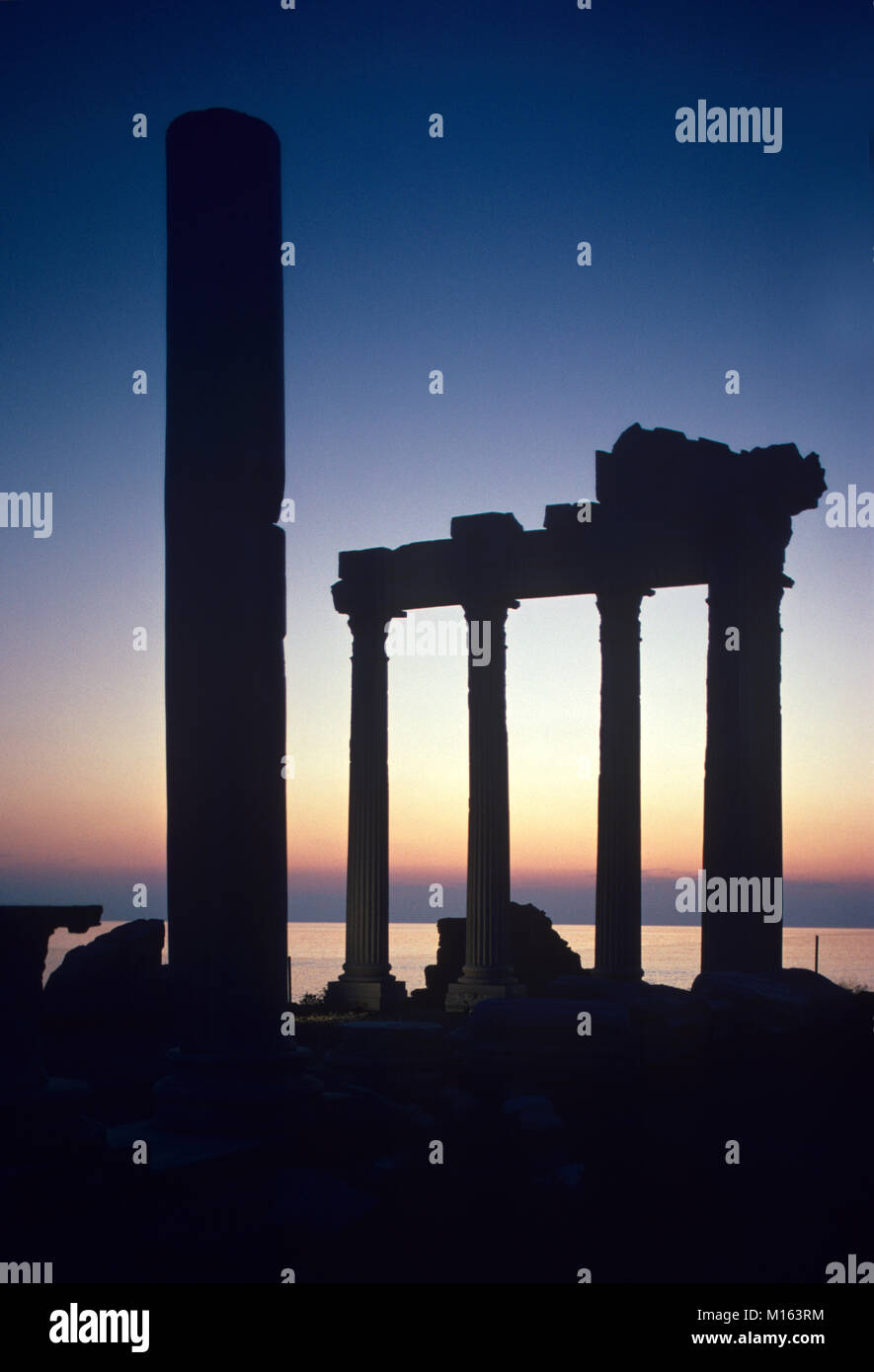 Dusk or Sunset over the Ancient Greek Temple of Apollo (c2nd) in the Remains or Ruins of the Antique Greek City of Side, on the Side Peninsula Overlooking the Mediterranean Sea, Antalya, Turkey Stock Photo