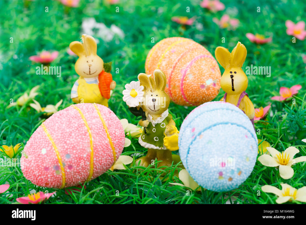 Easter bunny and egg candles on artificial grass background Stock Photo ...