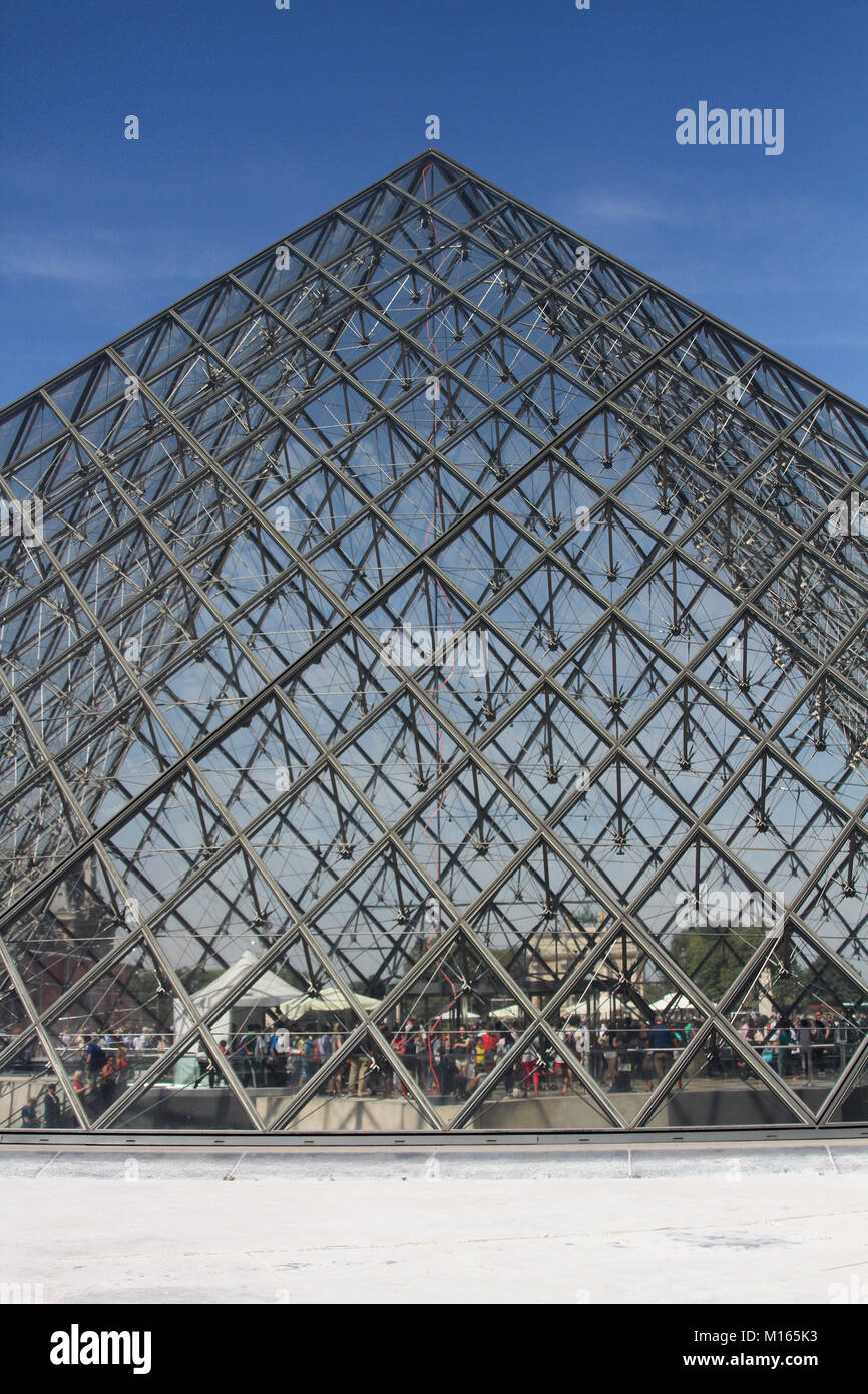 Close-up of the Louvre Pyramid (Pyramide du Louvre) against blue sky in the main courtyard (Cour Napoleon), Paris, France. Stock Photo