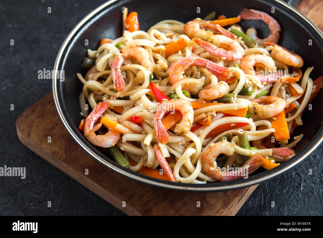 Stir fry with udon noodles, shrimps (prawns) and vegetables. Asian