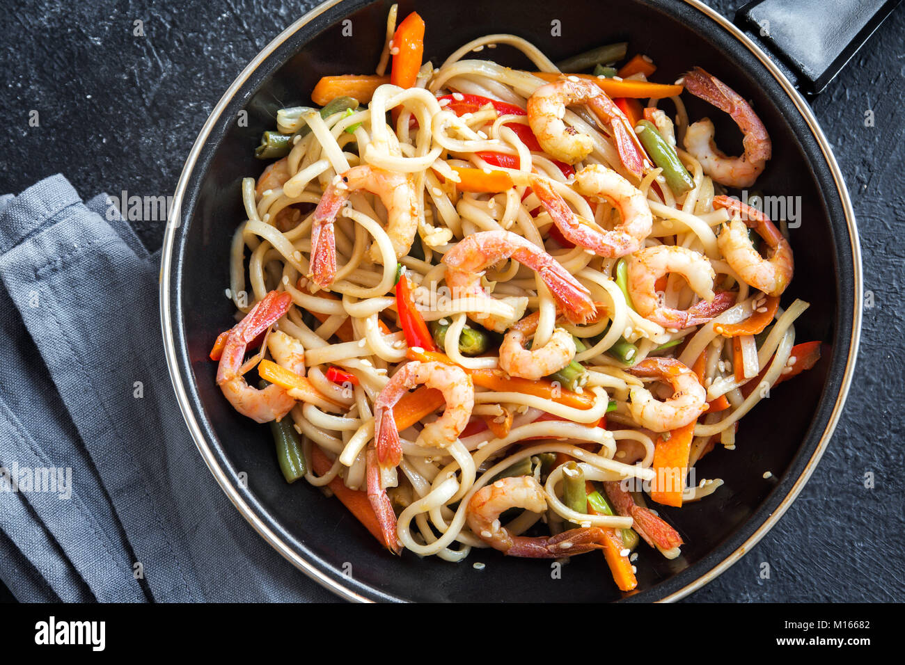 Stir fry with udon noodles, shrimps (prawns) and vegetables. Asian