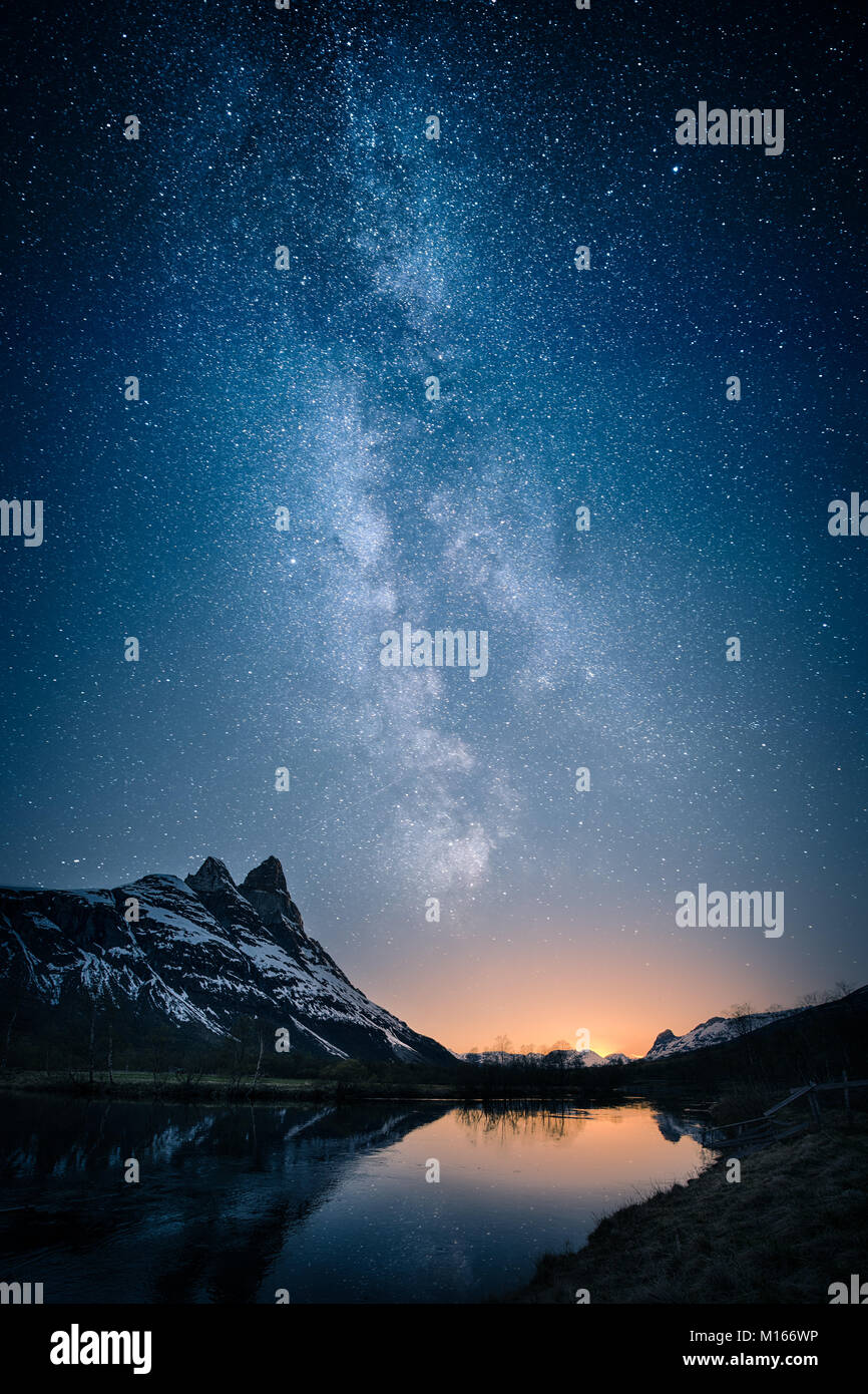 Beautiful view of milky way glowing on the sky with mountains and river and reflections of stars Stock Photo
