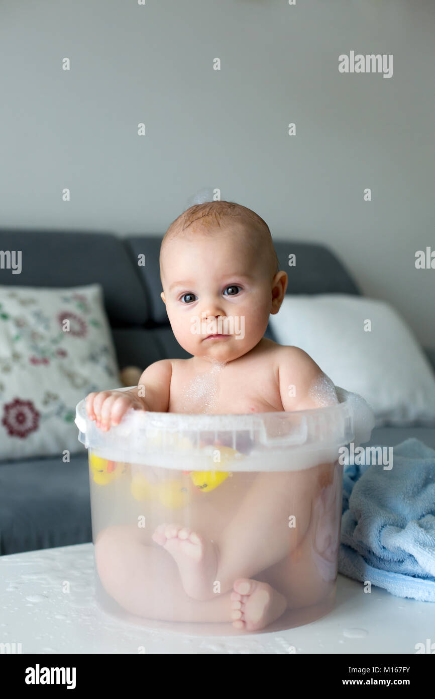 Cute Little Four Month Old Baby Boy Playing In Bucket Full With Water