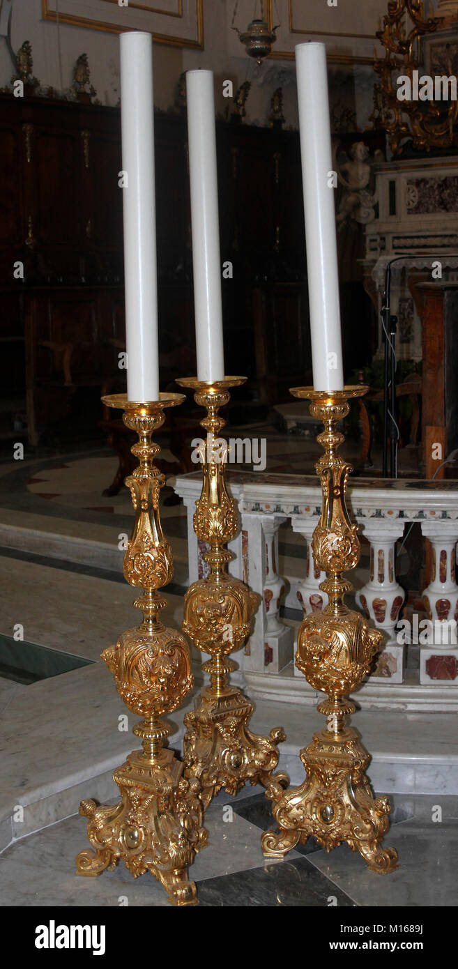 Three church candlesticks on altar candle stands inside the Church