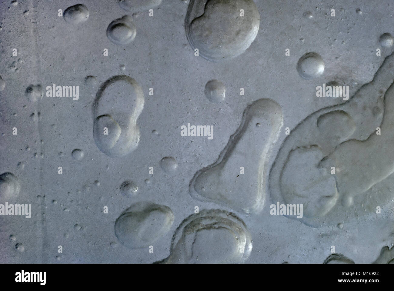 background, texture - gray rough concrete wall with caverns, reminiscent of the lunar surface Stock Photo