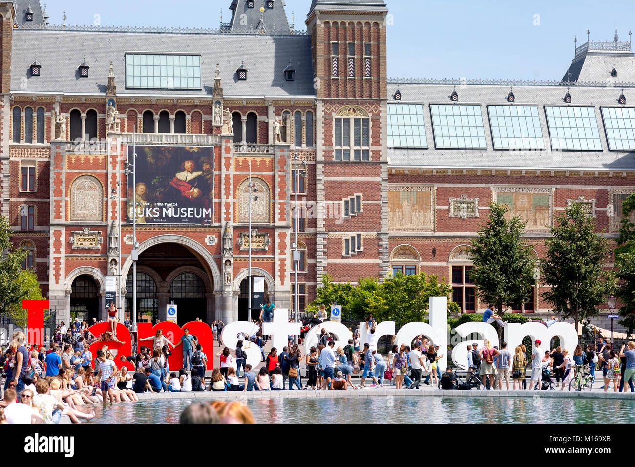 People relaxing and having fun on a waem sunny day near the Rijks Museum building, Amsterdam, Netherlands Stock Photo