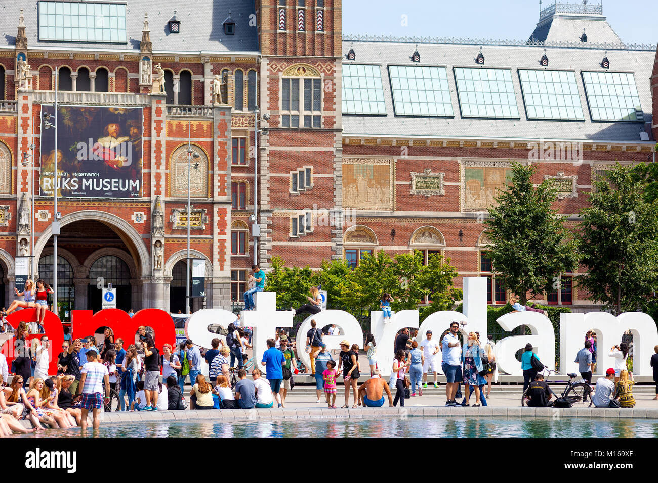 People relaxing and having fun on a waem sunny day near the Rijks Museum building, Amsterdam, Netherlands Stock Photo