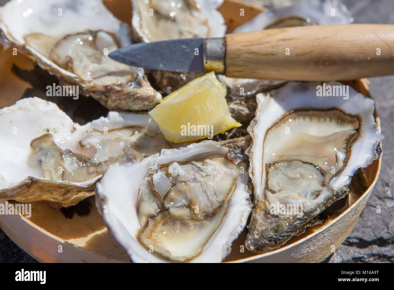 Tray with oysters, lemon and oyster knife at a street fair, Portbail, Cotentin, la Manche