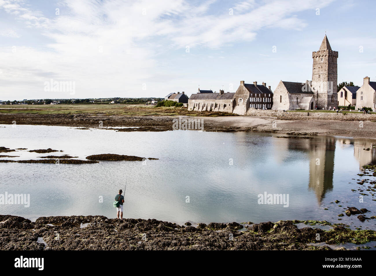 Angler in the mud flats in front of the village of Portbail, Portbail