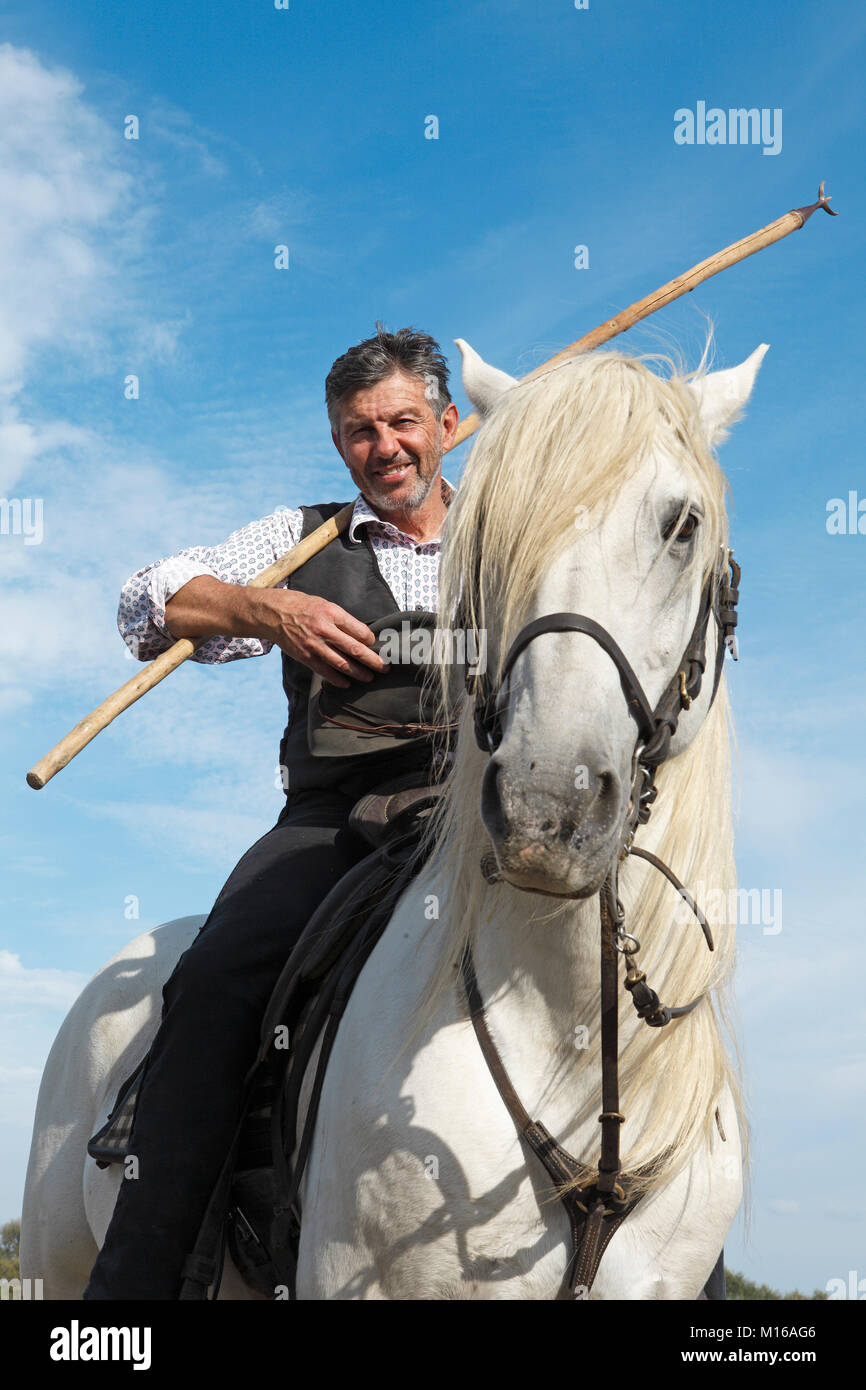 Gardian or traditional bull herder in typical working clothes on a Camargue horse, Le Grau-du-Roi, Camargue, France Stock Photo