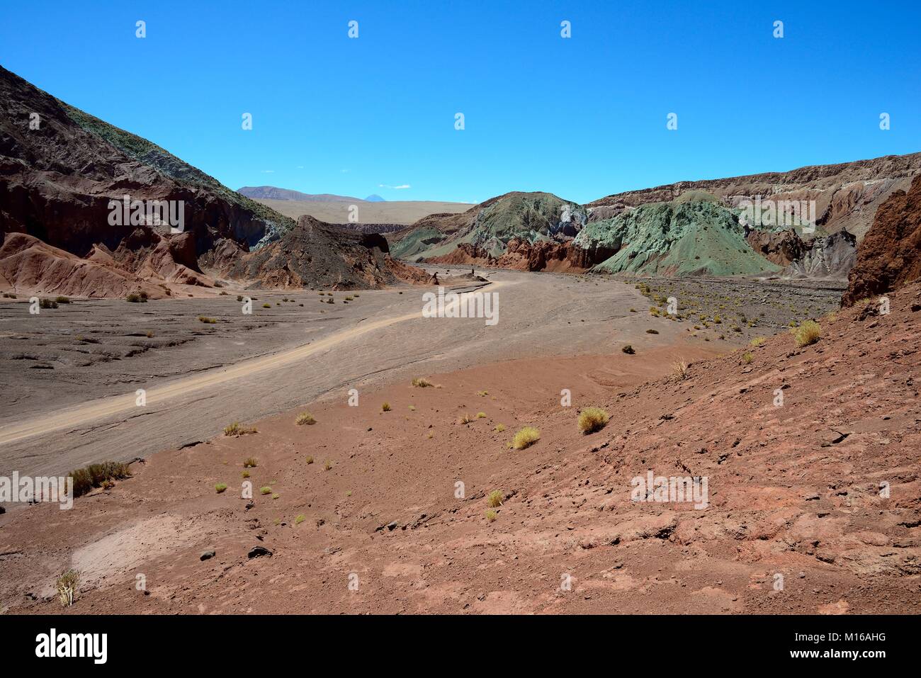 Desert landscape with dirt road in the Rainbow Valley, Valle Arcoiris, near San Pedro de Atacama, Región de Antofagasta, Chile Stock Photo