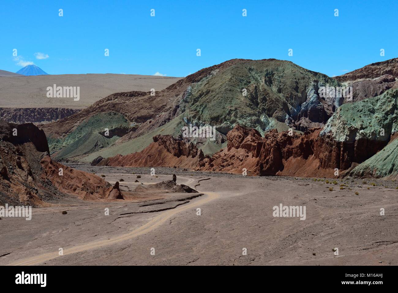 Desert landscape with dirt road in the Rainbow Valley, Valle Arcoiris, near San Pedro de Atacama, Región de Antofagasta, Chile Stock Photo