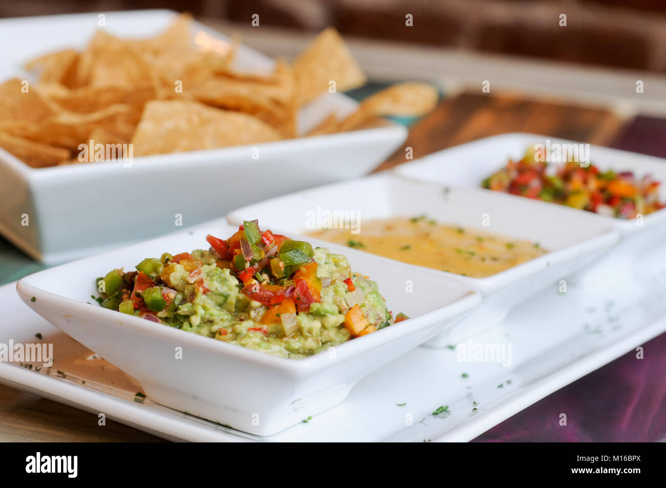 Corn chips and dip. Pico de Gallo, Queso and Guacamole Stock Photo Alamy
