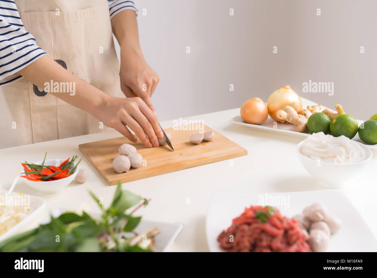 Female chef prepare traditional Vietnamese soup Pho bo with herbs, meat, rice noodles Stock Photo