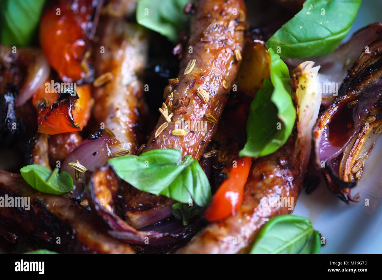Sausages with fennel seeds, onions, peppers and basil. Summer food. Barbecue food. Bill Granger recipe. Stock Photo