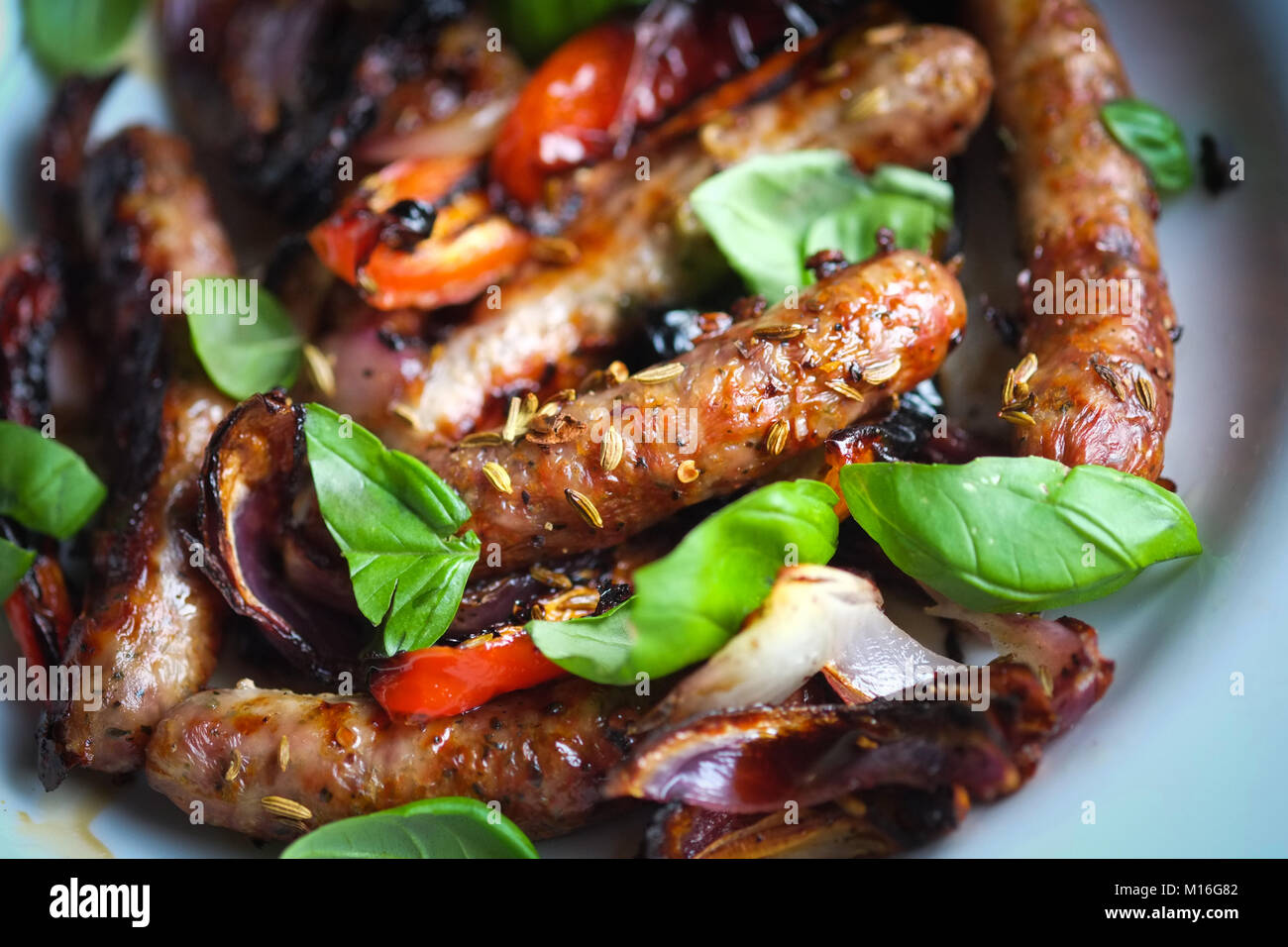 Sausages with fennel seeds, onions, peppers and basil. Summer food. Barbecue food. Bill Granger recipe. Stock Photo