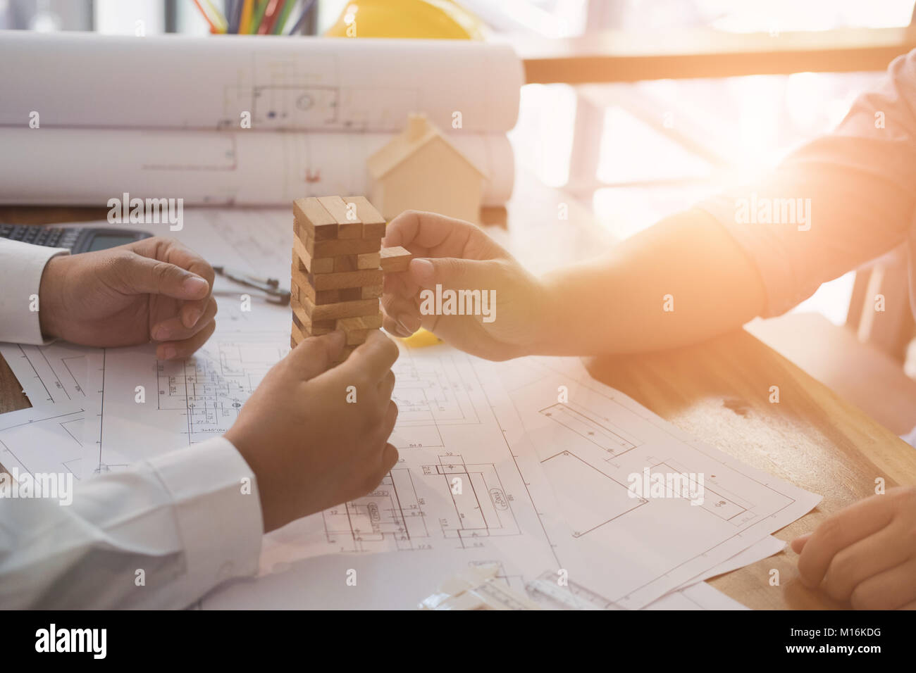 engineer & architect playing wood block games on blueprint of ...