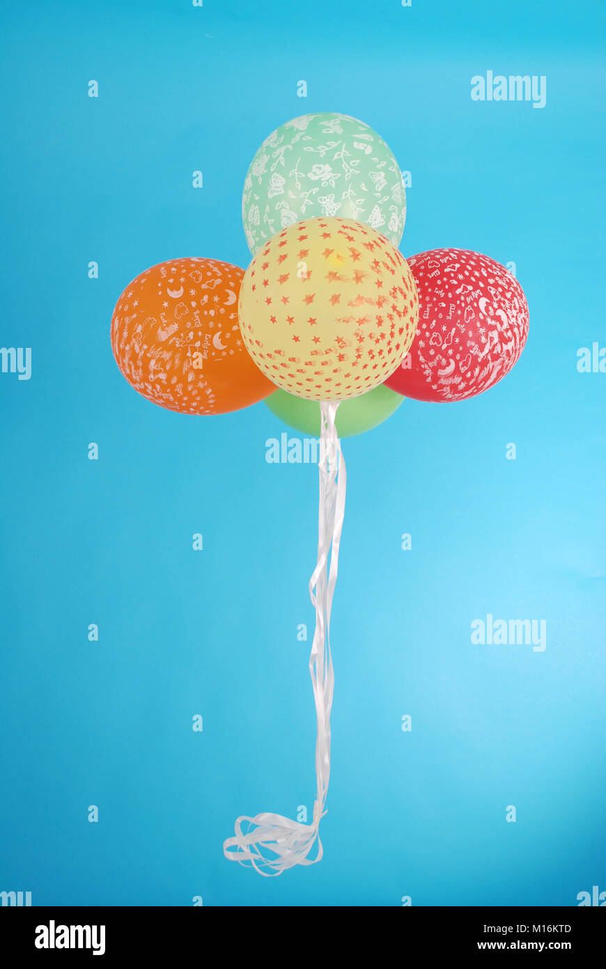 five balloons on blue background Stock Photo - Alamy