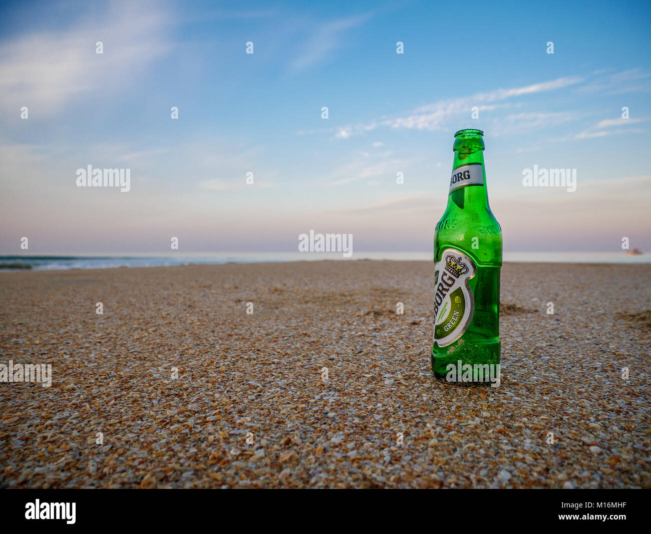 Goa, India - December, 22 2017 :A cold bottle of Tuborg in the sand on a hot, summer's day. Tuborg is a Danish brewing company founded in 1873 on a ha Stock Photo