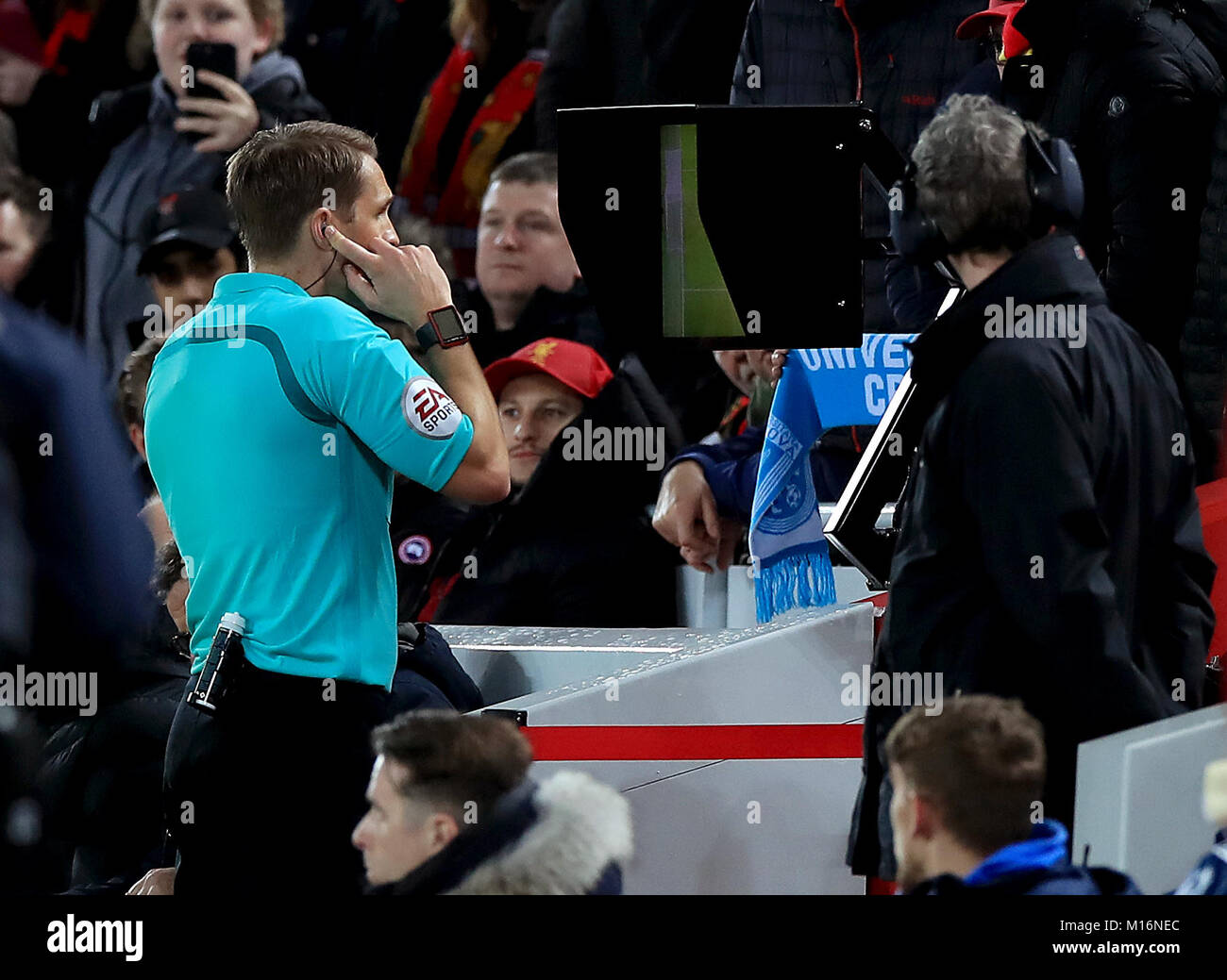 Match referee Craig Pawson uses the Video Assistant Referee to give a