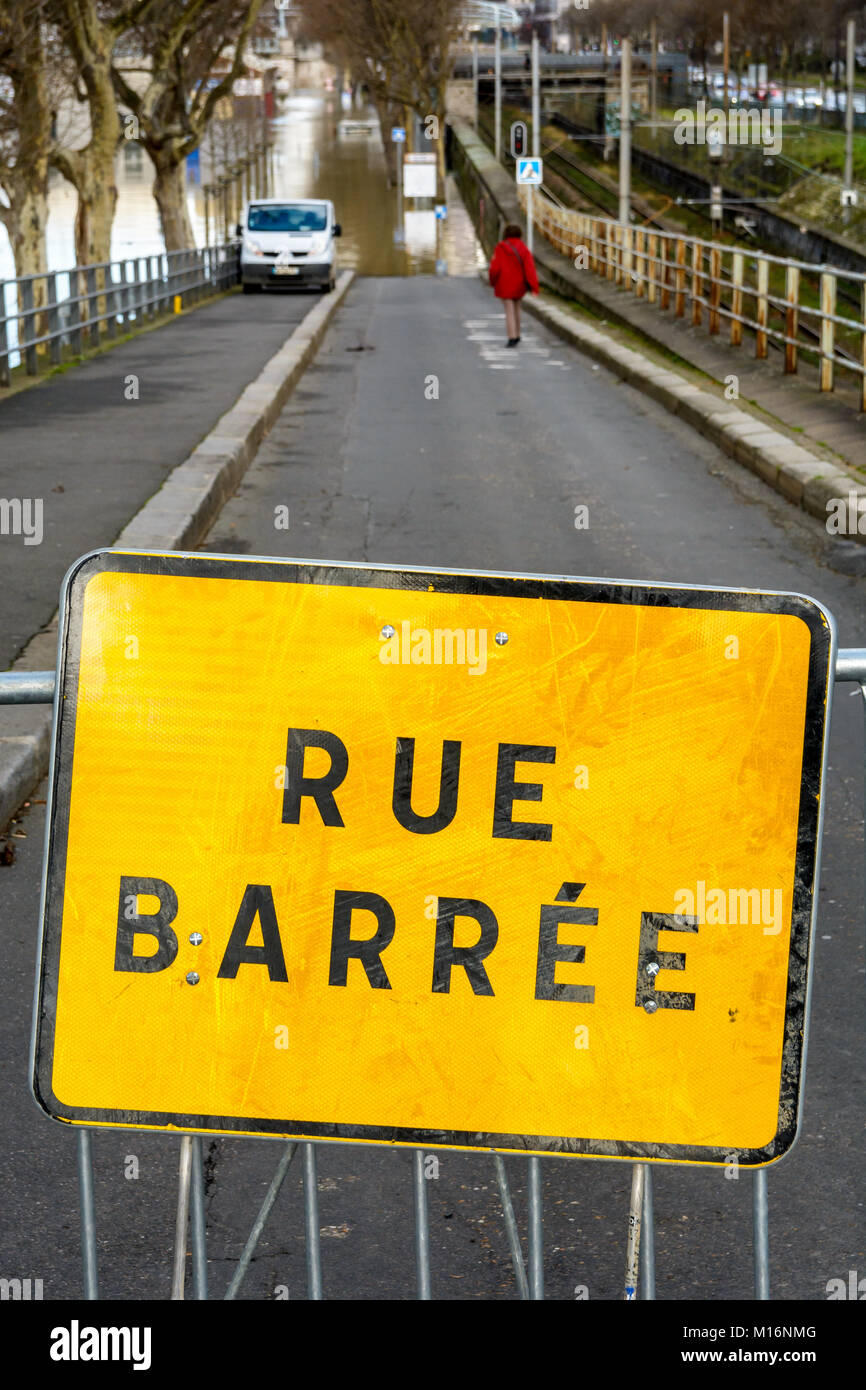 Paris, France - January 26, 2018: The road going down to the Grenelle port, along the RER C railway, is closed by a safety barrier after the Seine flo Stock Photo