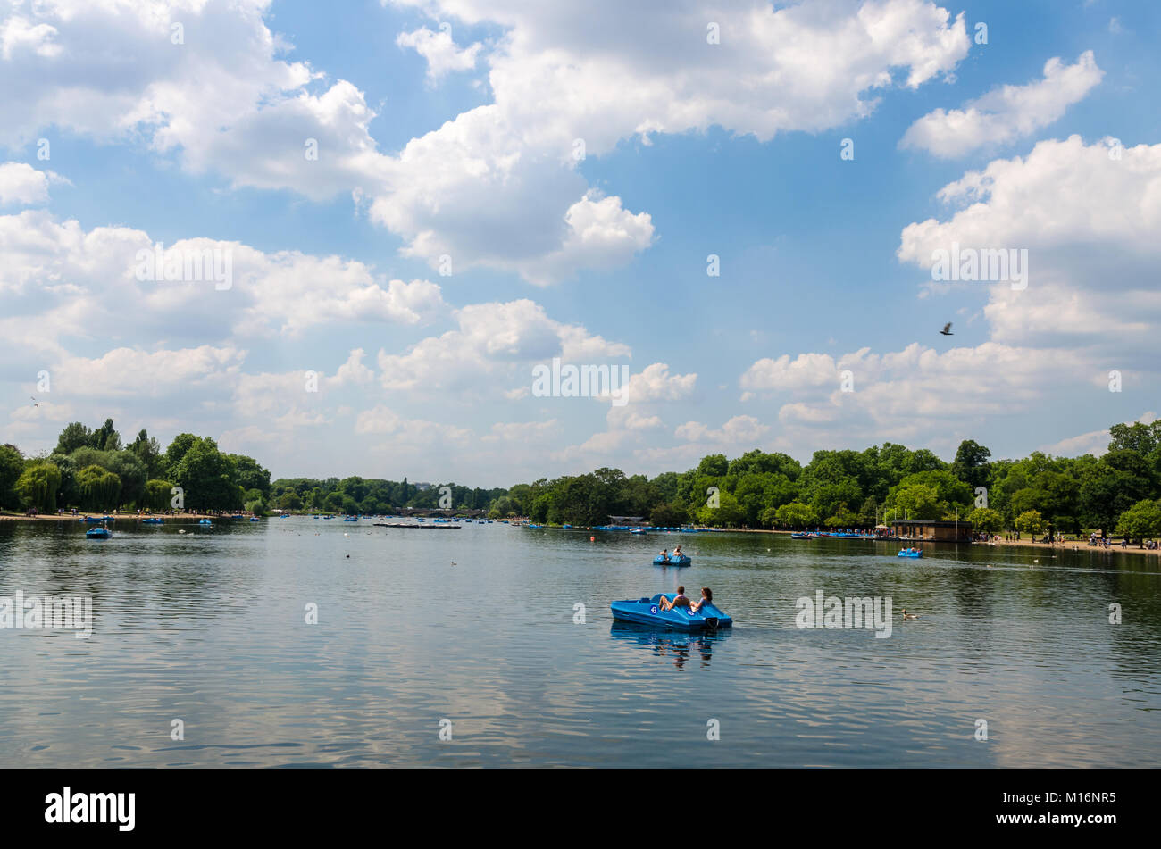 Couples and tourists enjoy boating activities on The Serpentine at Hyde Park in summer, London, United Kingdom Stock Photo