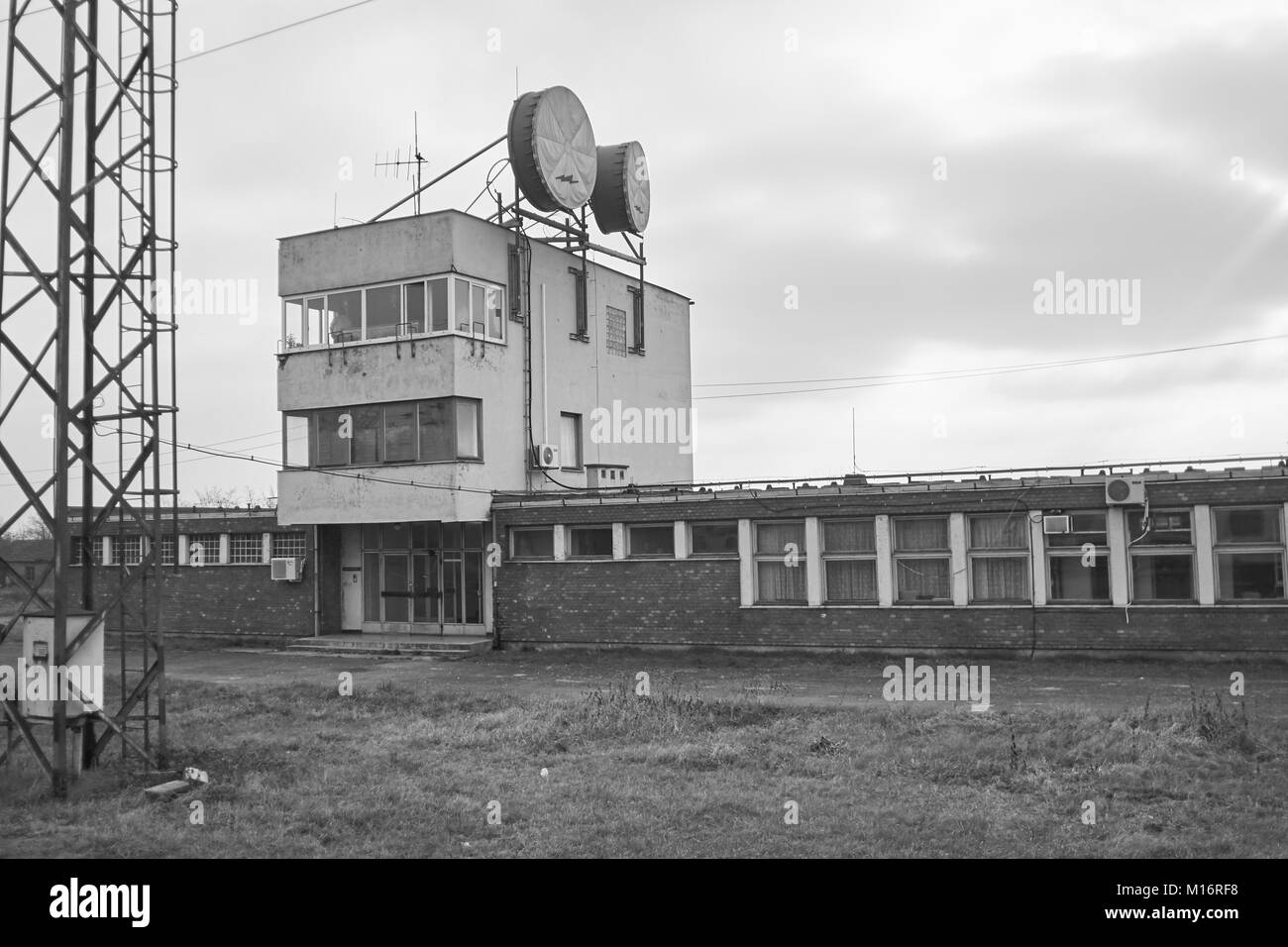 A soviet era communications station next to the rail lines in rural Hungary with two workers in the window Stock Photo