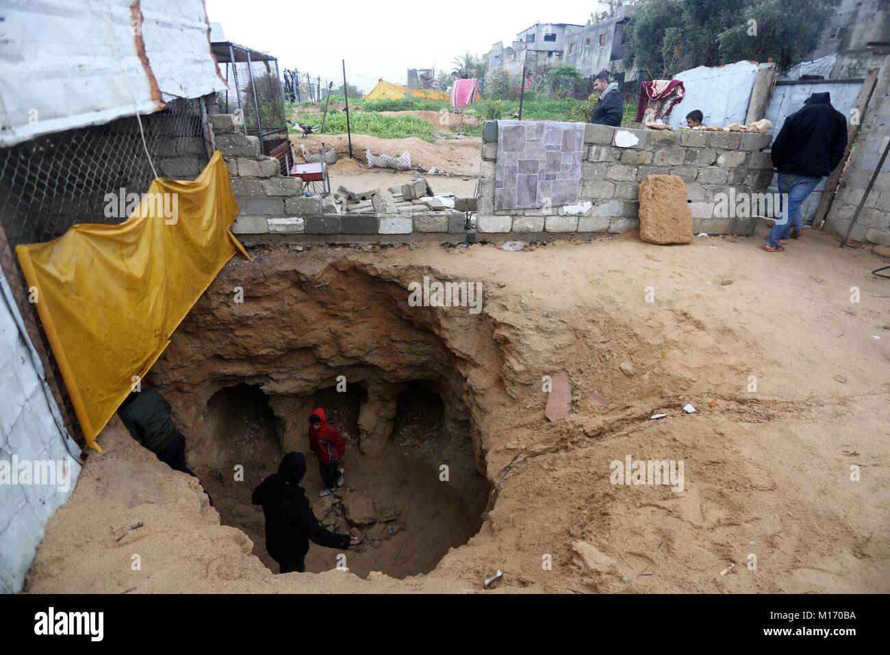 Beit Hanoun, Gaza Strip, Palestinian Territory. 28th Jan, 2018. Palestinians gather at a freshly-discovered cemetery which was found by Abdelkarim al-Kafarna in his backyard in town of Beit Hanoun, in the northern Gaza strip on January 27, 2018. Experts said the graves were part of a loculus tomb that possibly dates from the late Roman-Byzantine era in the fourth to sixth century CE where Gaza was part of the far-flung Roman Empire Credit: Mohammed Asad/APA Images/ZUMA Wire/Alamy Live News Stock Photo