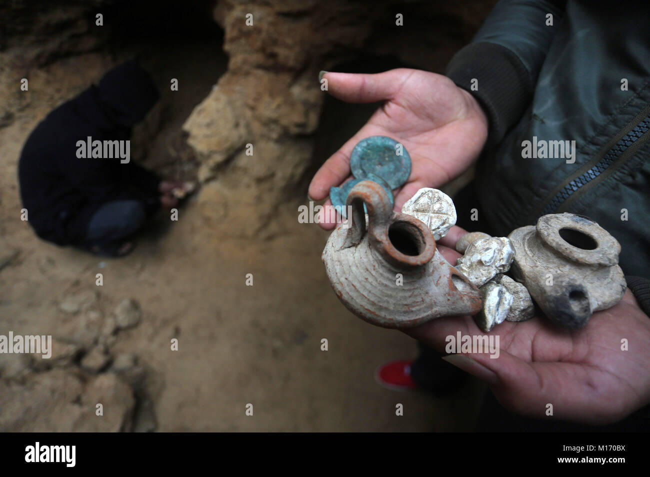 Beit Hanoun, Gaza Strip, Palestinian Territory. 28th Jan, 2018. A Palestinian man holds pottery fragments at a freshly-discovered cemetery which was found by Abdelkarim al-Kafarna in his backyard in town of Beit Hanoun, in the northern Gaza strip on January 27, 2018. Experts said the graves were part of a loculus tomb that possibly dates from the late Roman-Byzantine era in the fourth to sixth century CE where Gaza was part of the far-flung Roman Empire Credit: Mohammed Asad/APA Images/ZUMA Wire/Alamy Live News Stock Photo
