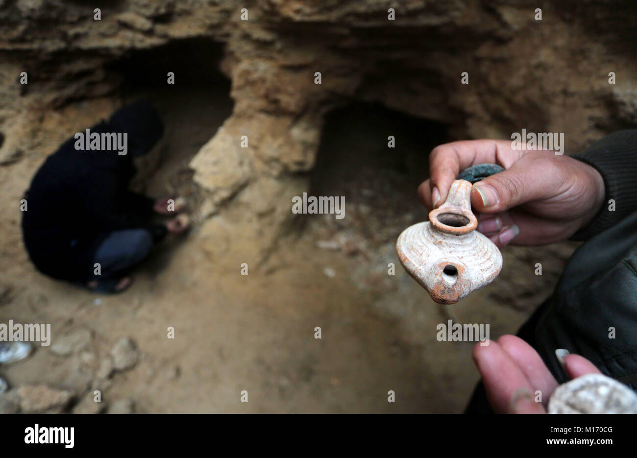 Beit Hanoun, Gaza Strip, Palestinian Territory. 28th Jan, 2018. A Palestinian man holds pottery fragments at a freshly-discovered cemetery which was found by Abdelkarim al-Kafarna in his backyard in town of Beit Hanoun, in the northern Gaza strip on January 27, 2018. Experts said the graves were part of a loculus tomb that possibly dates from the late Roman-Byzantine era in the fourth to sixth century CE where Gaza was part of the far-flung Roman Empire Credit: Mohammed Asad/APA Images/ZUMA Wire/Alamy Live News Stock Photo