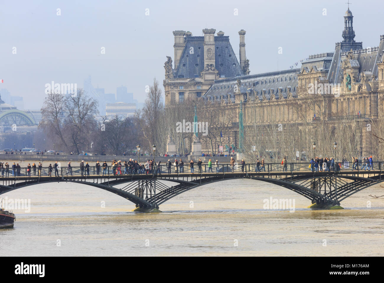 Paris, France, 27th Jan 2018.  Flooding in Paris. The louvre museum on the left with people on the Pont des Arts in the foreground. The river Seine was expected to reach its peak between Saturday afternoon and early Sunday morning.Credit: Imageplotter News and Sports/Alamy Live News Stock Photo