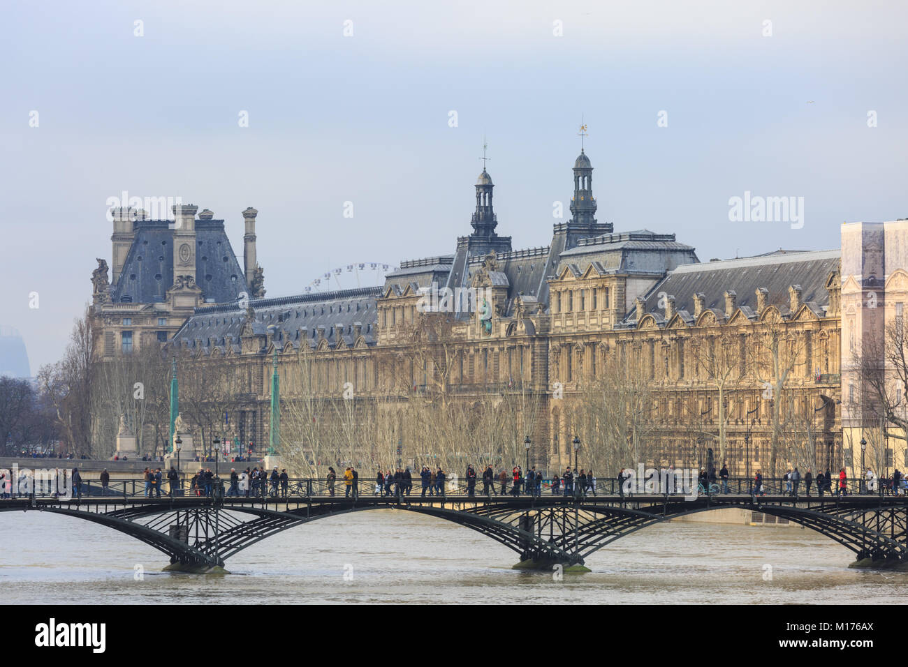 Paris, France, 27th Jan 2018.  Flooding in Paris. The louvre museum on the left with people on the Pont des Arts in the foreground. The river Seine was expected to reach its peak between Saturday afternoon and early Sunday morning.Credit: Imageplotter News and Sports/Alamy Live News Stock Photo