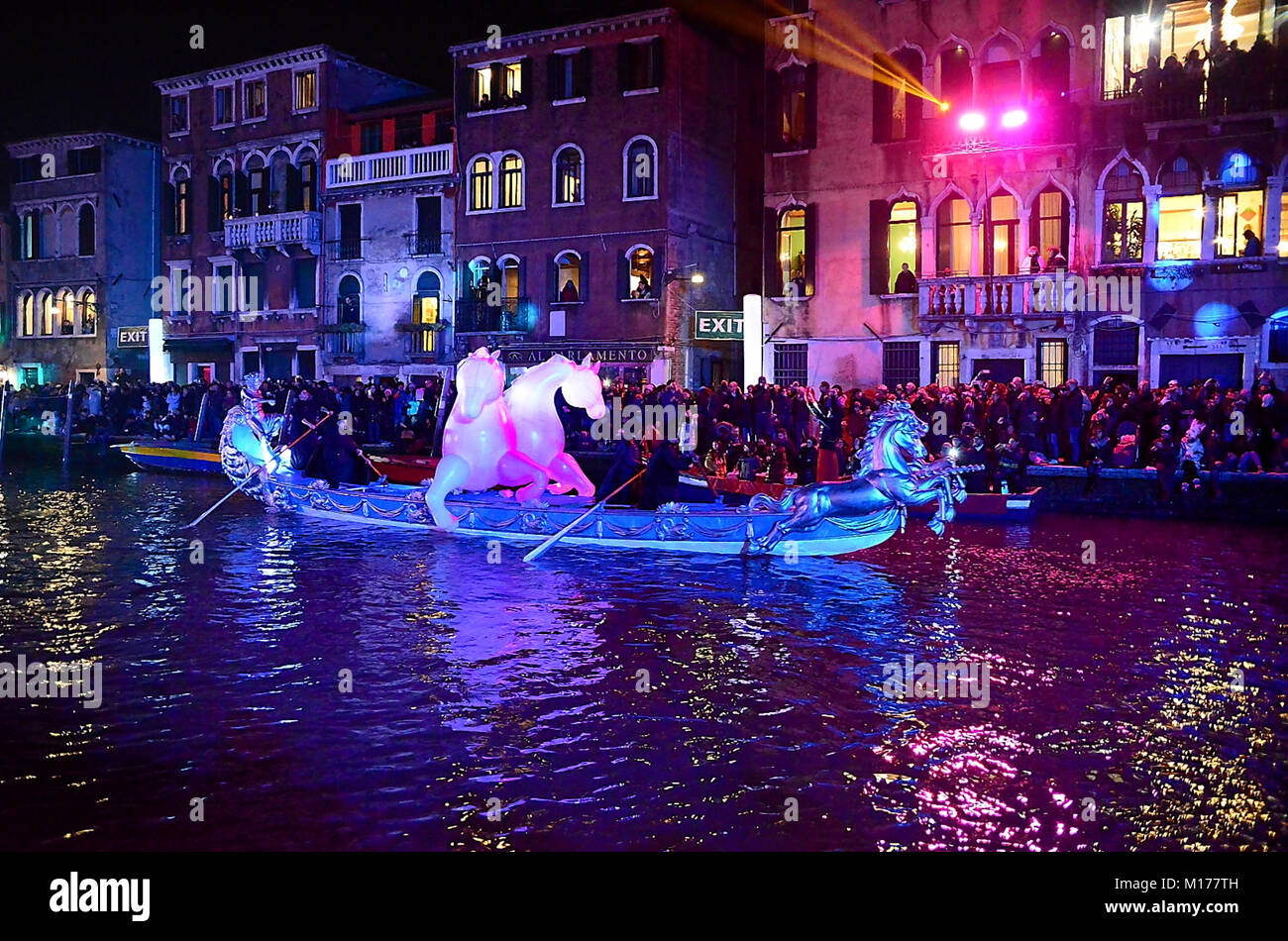 Venice, January 27th, 2018. The 2018 edition of the Venice Carnival opens with a colorful show on the water. Illuminated boats carry some 'papier-machè', circus animals and clowns, acrobats and fire-eaters. The show also pays a tribute to Federico Fellini's cinema and film music. Thousands of people enjoy the show from the banks. Stock Photo