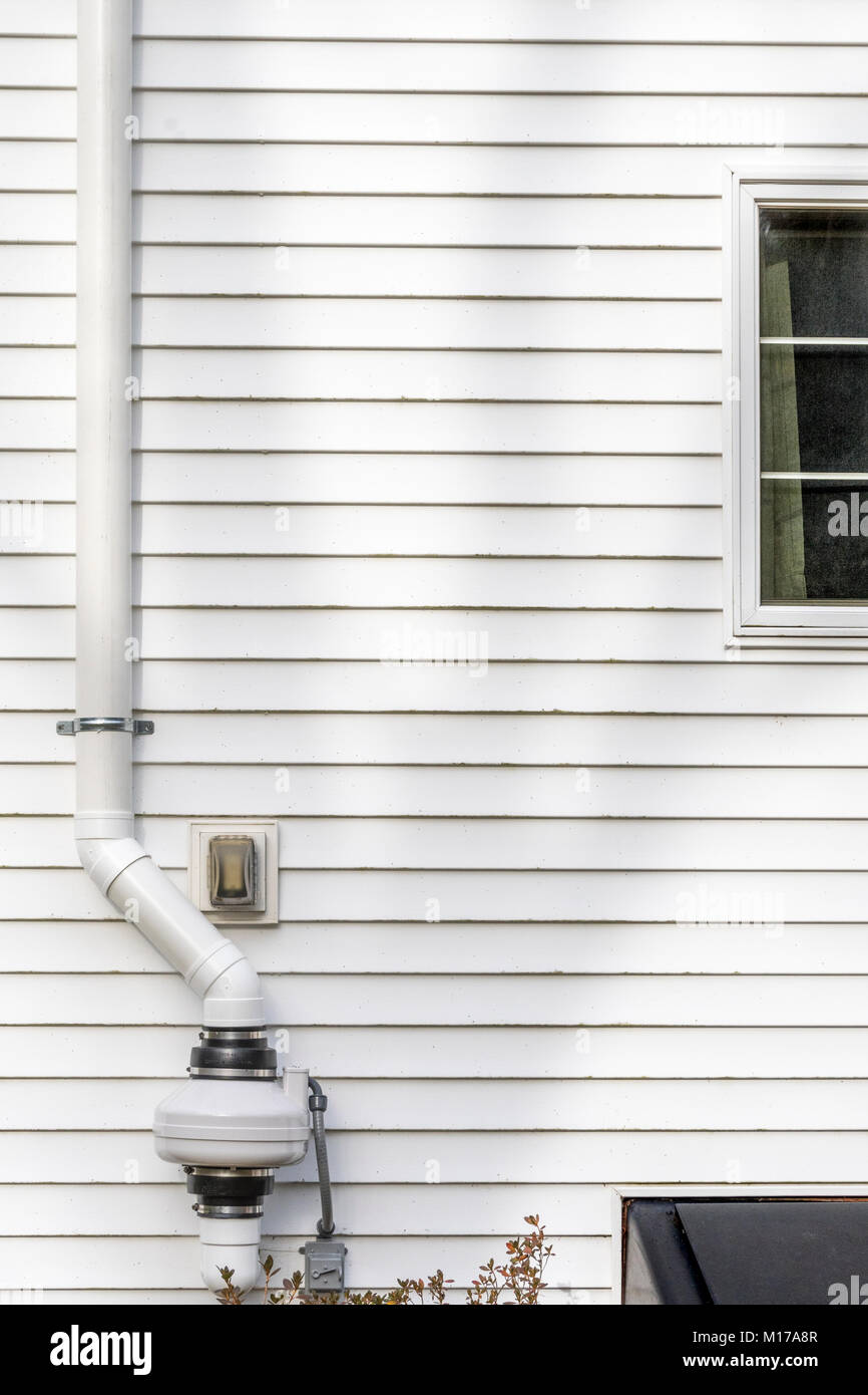 Radon air mitigation equipment mounted on the side of a residence in New Hampshire, the 'Granite State'. Stock Photo