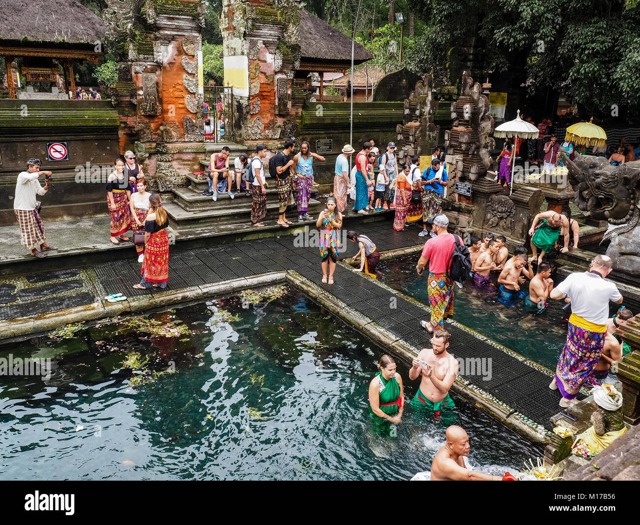 Tourists from different countries gather in Tirta Empul Temple to bath in holy water. Aerial picture of hinduism famous landmark witl a lot of people. Stock Photo