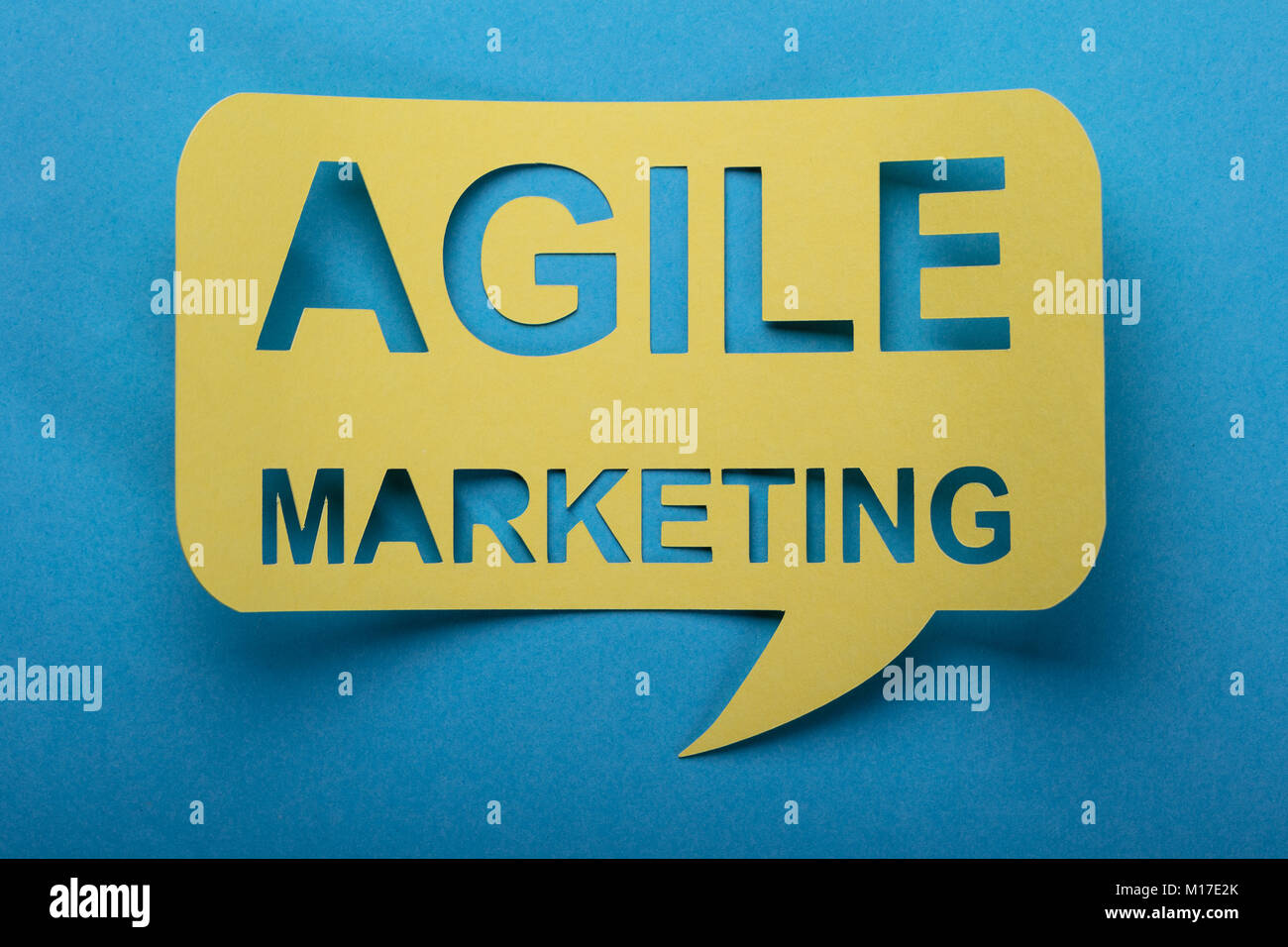 Agile Marketing Words Cut Out On Speech Bubble Over Blue Background Stock Photo
