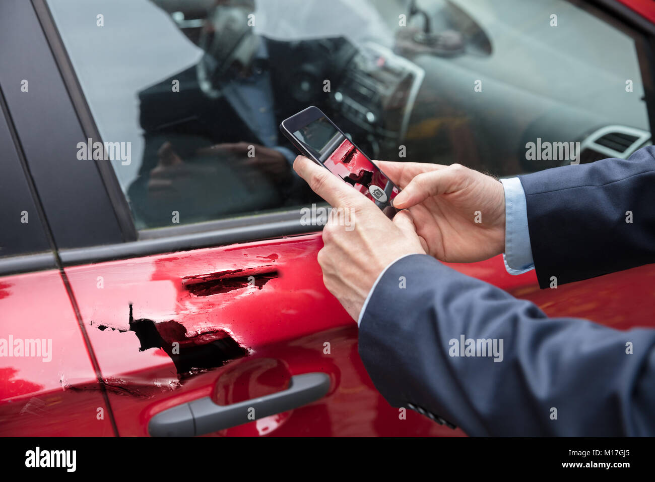 Close-up Of A Person Taking Picture Of Damaged Car On Mobile Phone Stock Photo