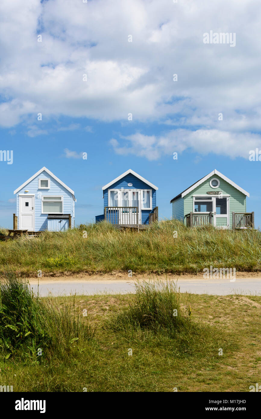 Colourful painted wooden beach huts among the sand dunes at Mudeford Spit, near Christchurch, Dorset, England, UK, Europe Stock Photo