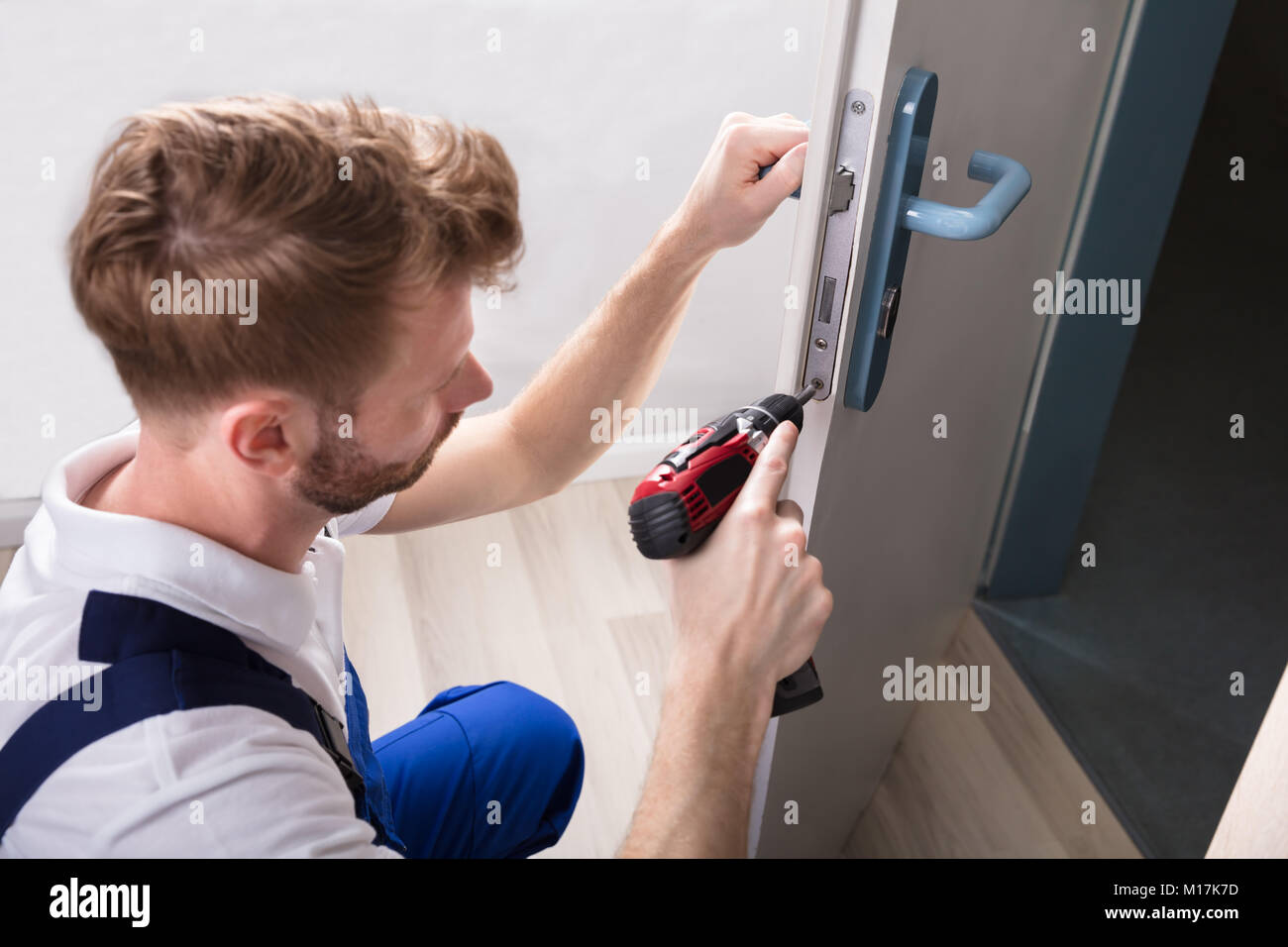 Young Carpenter Install Door Lock With Wireless Screwdriver Stock Photo