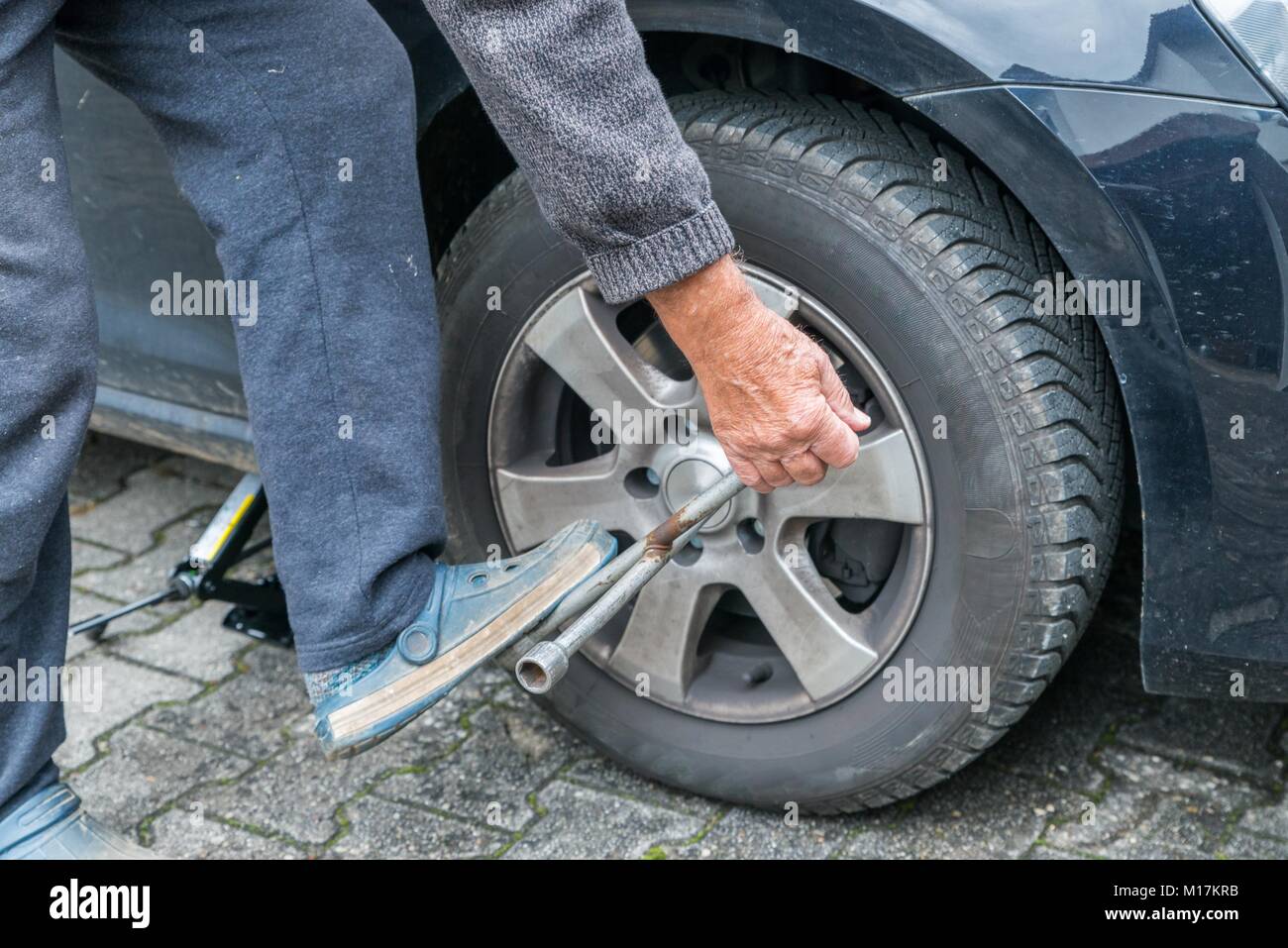 Manually tire change with fourway socket wrench Stock Photo Alamy