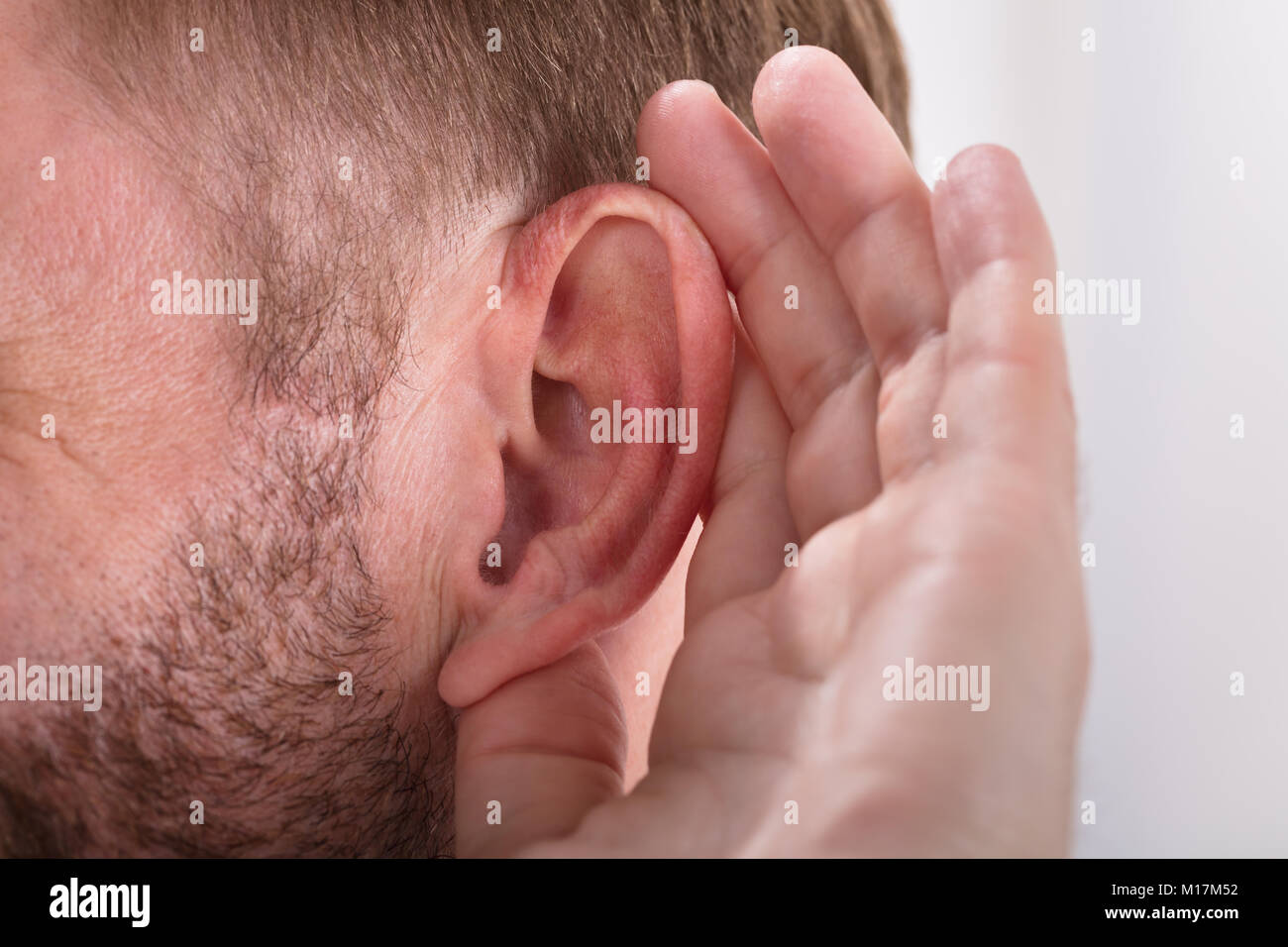 Close-up Of A Man Trying To Hear With Hand Over Ear Stock Photo