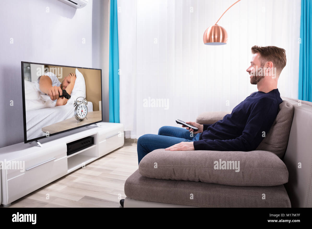 Man sitting on sofa watching tv hi-res stock photography and images - Alamy
